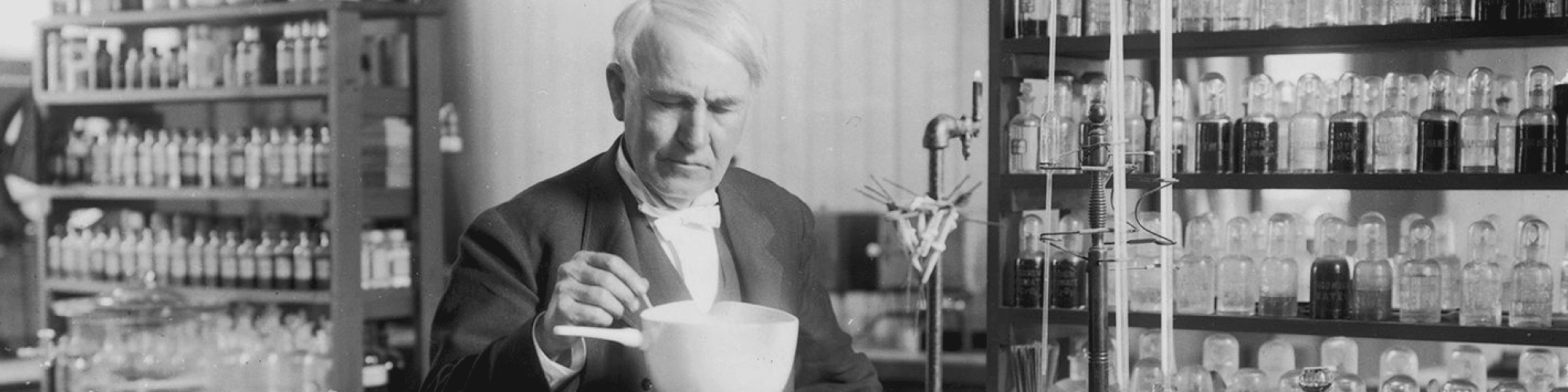 Thomas Edison in his lab conducting an experiment with beakers.